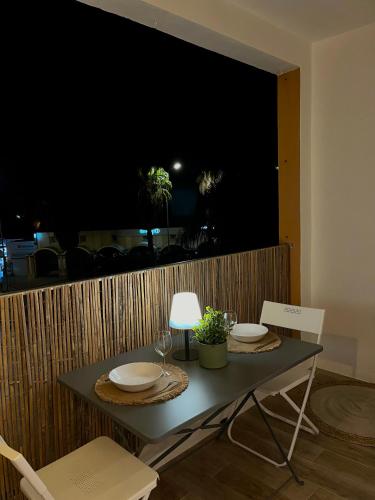 une table avec deux chaises et une table avec des assiettes et des verres dans l'établissement Logement d'exception sur le Port, à Hyères