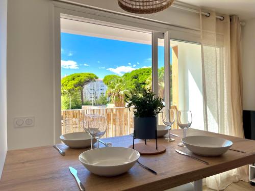 - une table en bois avec des bols et des verres à vin dans l'établissement Logement d'exception sur le Port, à Hyères