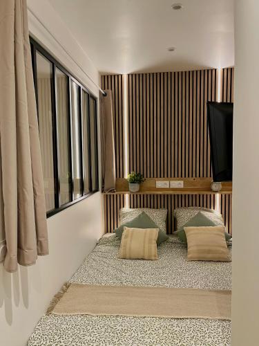 Cette chambre dispose d'un canapé avec des oreillers et d'une télévision. dans l'établissement Logement d'exception sur le Port, à Hyères