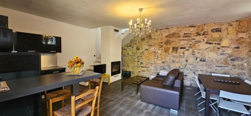 a kitchen and dining room with a stone wall at Baita La Lidia in Sala Comacina