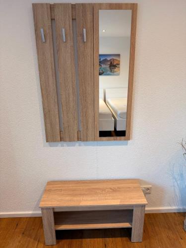 a mirror on a wall with a table in a room at Milis Apartments in Radolfzell am Bodensee