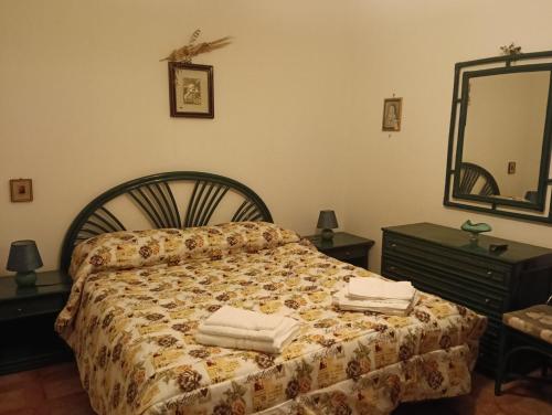 a bedroom with a bed with towels on it at Villa della Concordia in Plaia Grande