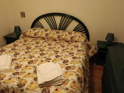 a bed with a comforter and towels on it at Villa della Concordia in Plaia Grande