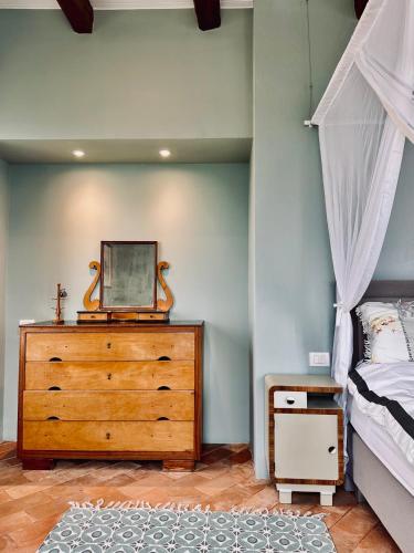 a bedroom with a wooden dresser and a bed at Palazzo Minzoni in SantʼIppolito