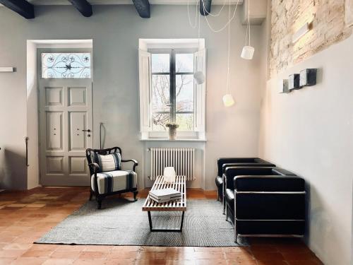 a living room with a couch and chairs and a door at Palazzo Minzoni in SantʼIppolito