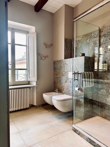 a bathroom with two sinks and a glass shower at Palazzo Minzoni in SantʼIppolito
