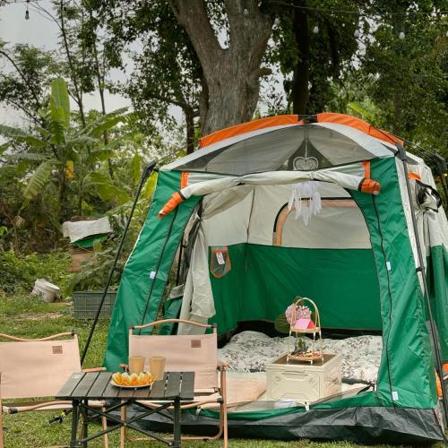 a tent with a table and chairs in front of it at Nú Camping in Minh Nông