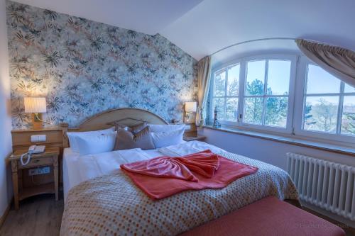 a bedroom with a large bed and a window at Romantik Hotel Namenlos in Ahrenshoop