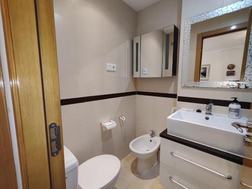 une salle de bain avec des toilettes blanches et un lavabo dans l'établissement EDIFICIO JARDINES DEL MAR II en Magic World, à El Borseral
