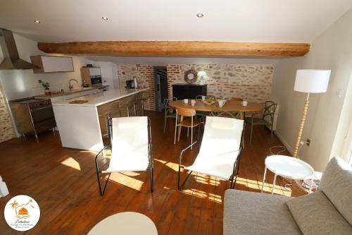 une cuisine et un salon avec une table et des chaises dans l'établissement Superbe maison avec terrasse a quelques minutes des plages, à Latour-Bas-Elne