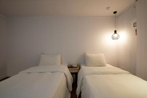 two beds sitting next to each other in a room at 케일라호텔 in Uijeongbu
