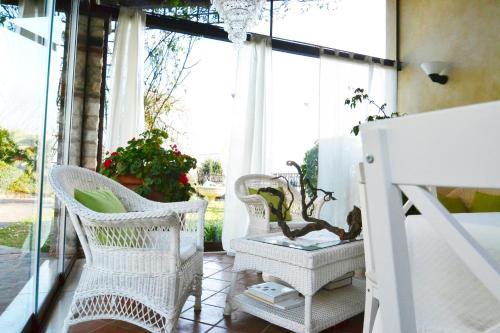 a porch with white wicker chairs and a window at La Collina delle Acacie in Grumolo Pedemonte