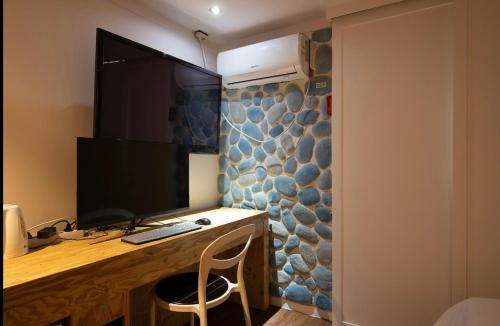 a desk with a computer and a monitor on a wall at 케일라호텔 in Uijeongbu