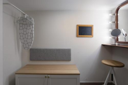 a white kitchen with a counter and a stool at Charming Stay in the 3 Cities in Cospicua