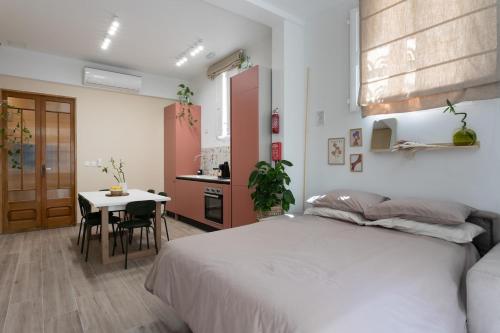 a bedroom with a bed and a table and a kitchen at Charming Stay in the 3 Cities in Cospicua