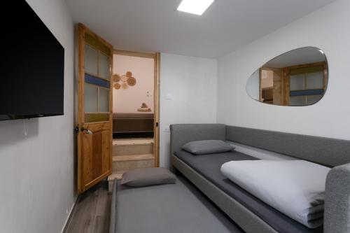 a small room with a couch and a mirror at Charming Stay in the 3 Cities in Cospicua