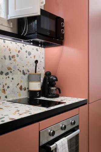 a kitchen with a stove and a microwave at Charming Stay in the 3 Cities in Cospicua