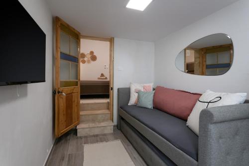 a living room with a couch and a mirror at Charming Stay in the 3 Cities in Cospicua
