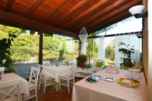 a dining room with tables and chairs and a large window at La Collina delle Acacie in Grumolo Pedemonte