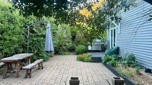 a patio with an umbrella and a bench and a table at Renovated villa in Little River in Little River