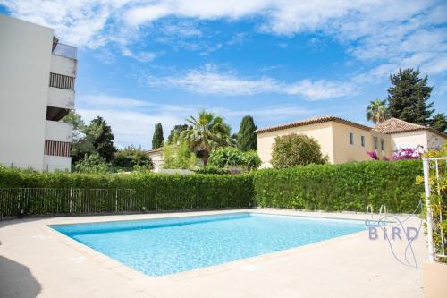 - une piscine dans une cour avec une haie dans l'établissement walk to beach with AC and swimpool, à Cagnes-sur-Mer