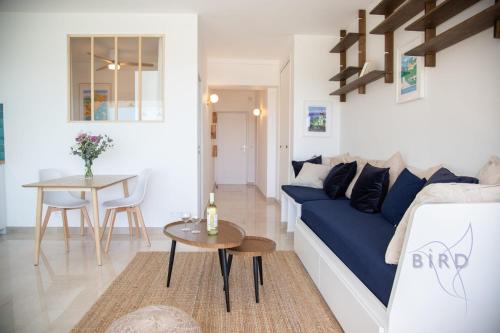 un salon avec un canapé bleu et une table dans l'établissement Marina Baie des Anges Ducal SEA VIEW AC, à Villeneuve-Loubet