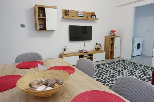 a dining room with a table and chairs and a television at Balcescu Apartment Self Check-in in Timişoara