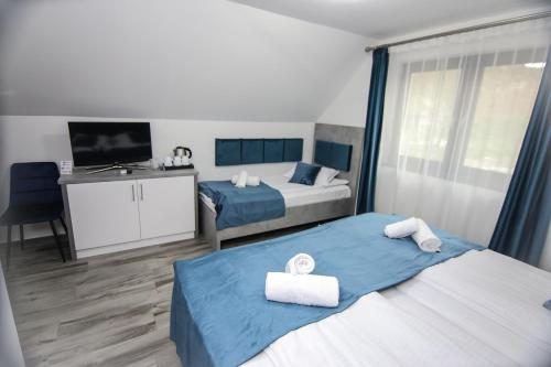 a hotel room with two beds and a television at Pensiunea Giulia in Turda