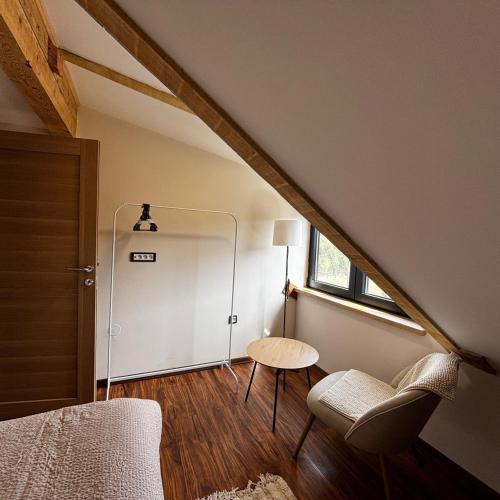 a attic room with a bed and a table and a door at Zlatiborski biser in Suljagići