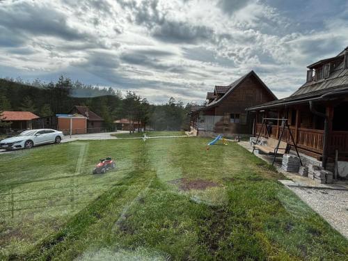 a yard with a kite in the grass next to a house at Zlatiborski biser in Suljagići