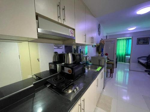 a kitchen with a sink and a stove in it at Sea Residences at Jireh in Pasay
