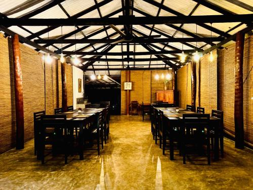 a restaurant with tables and chairs in a room at Queens Mount Eco Habitat in Balapitiya