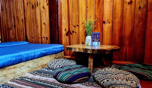 a room with a table and some pillows on a rug at Nasan Green Farm in Cao Bằng