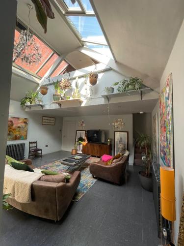 a large living room with couches and a skylight at Quirky house in Manchester