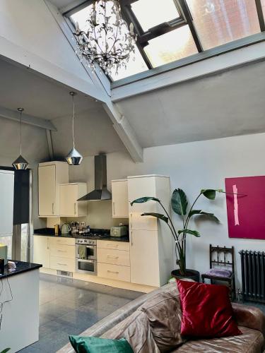 a living room with a couch and a kitchen at Quirky house in Manchester