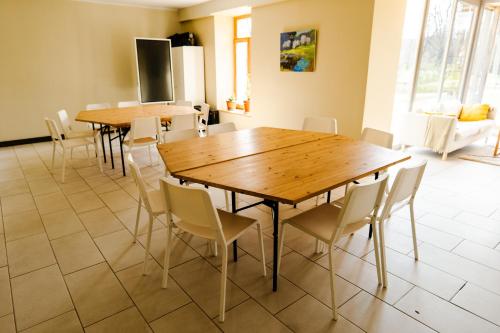 ein Esszimmer mit Holztischen und Stühlen in der Unterkunft Inovatorių slėnis/ Innovators' valley in Antalieptė