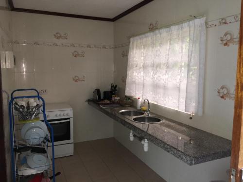 a small kitchen with a sink and a window at Skyblue Guesthouse - Self Catering in Baie Sainte Anne