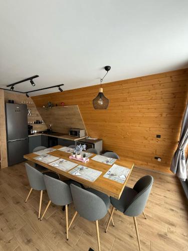 a dining room with a wooden table and chairs at A Dream Colibita in Colibiţa