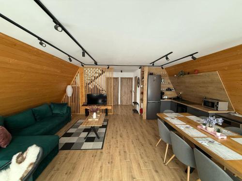 a living room with a green couch and a kitchen at A Dream Colibita in Colibiţa