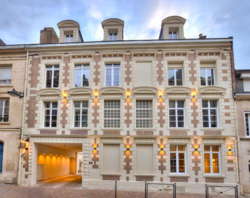a large brick building with windows at The Originals Boutique, Hôtel Les Coulisses du Théâtre, Saint-Quentin in Saint-Quentin