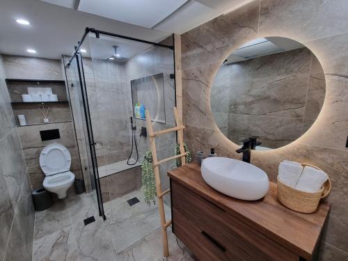 a bathroom with a sink and a shower at Sea Suites - סוויטות מהממות עם מרפסת ליד המרינה באשקלון in Ashqelon