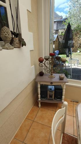 a small table in a room with a window at La maison d`hôtes de Constance in Le Mans