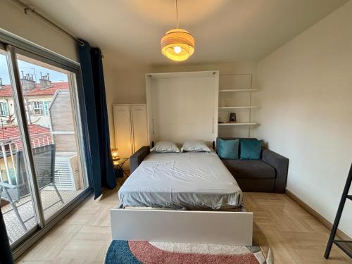 une chambre avec un lit, un canapé et une fenêtre dans l'établissement Cozy Apt with balcony - Garibaldi Port, à Nice