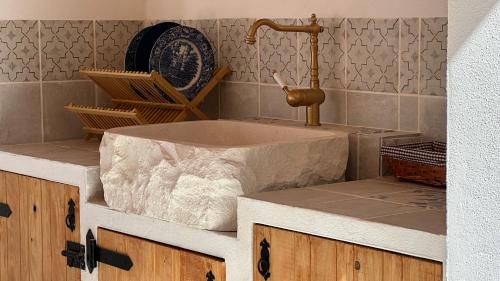 a bathroom with a marble sink and a faucet at Casa Palmerita a 7 minutos andando de una playa de aguas cristalinas in Teulada
