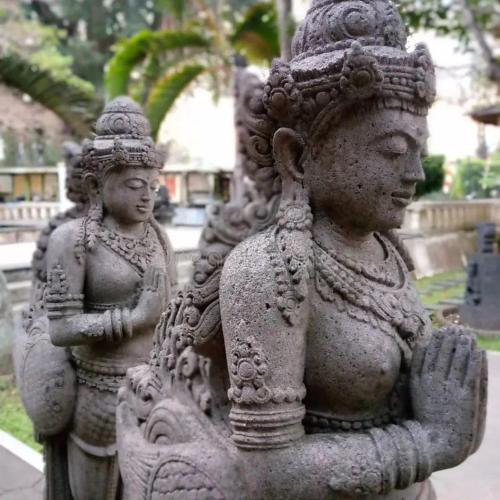 two stone statues are standing next to each other at Puunee Wild River Villa's Borobudur in Borobudur