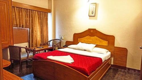 a bedroom with a bed with a red blanket at Seagate Church View Resorts in Velānganni