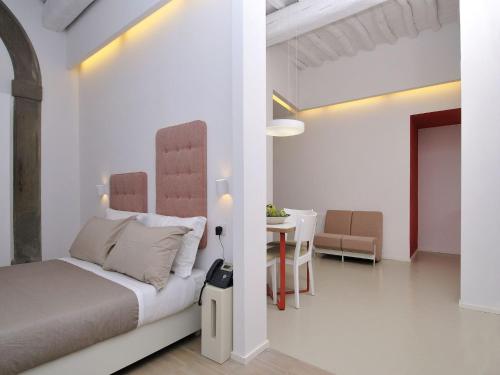 a white bedroom with a bed and a table at Villa Aruch in Florence