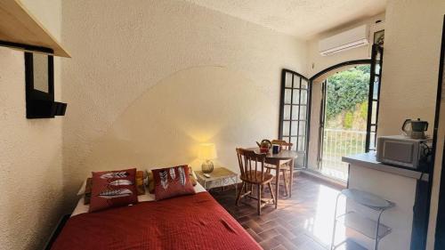 - une chambre avec un lit et une table avec un four micro-ondes dans l'établissement Studio 5 PORTO LUMIO, à Lumio