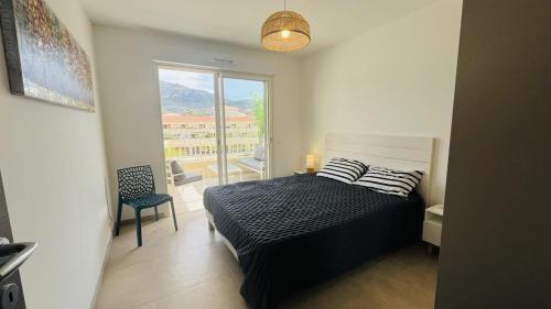 une chambre avec un lit et une grande fenêtre dans l'établissement Appartement MARINA 1 LUMIO, à Lumio