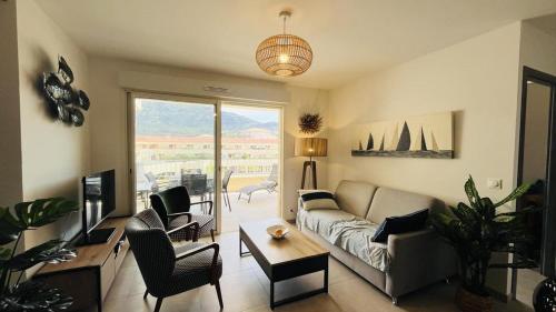 un salon avec un canapé et une table dans l'établissement Appartement MARINA 1 LUMIO, à Lumio